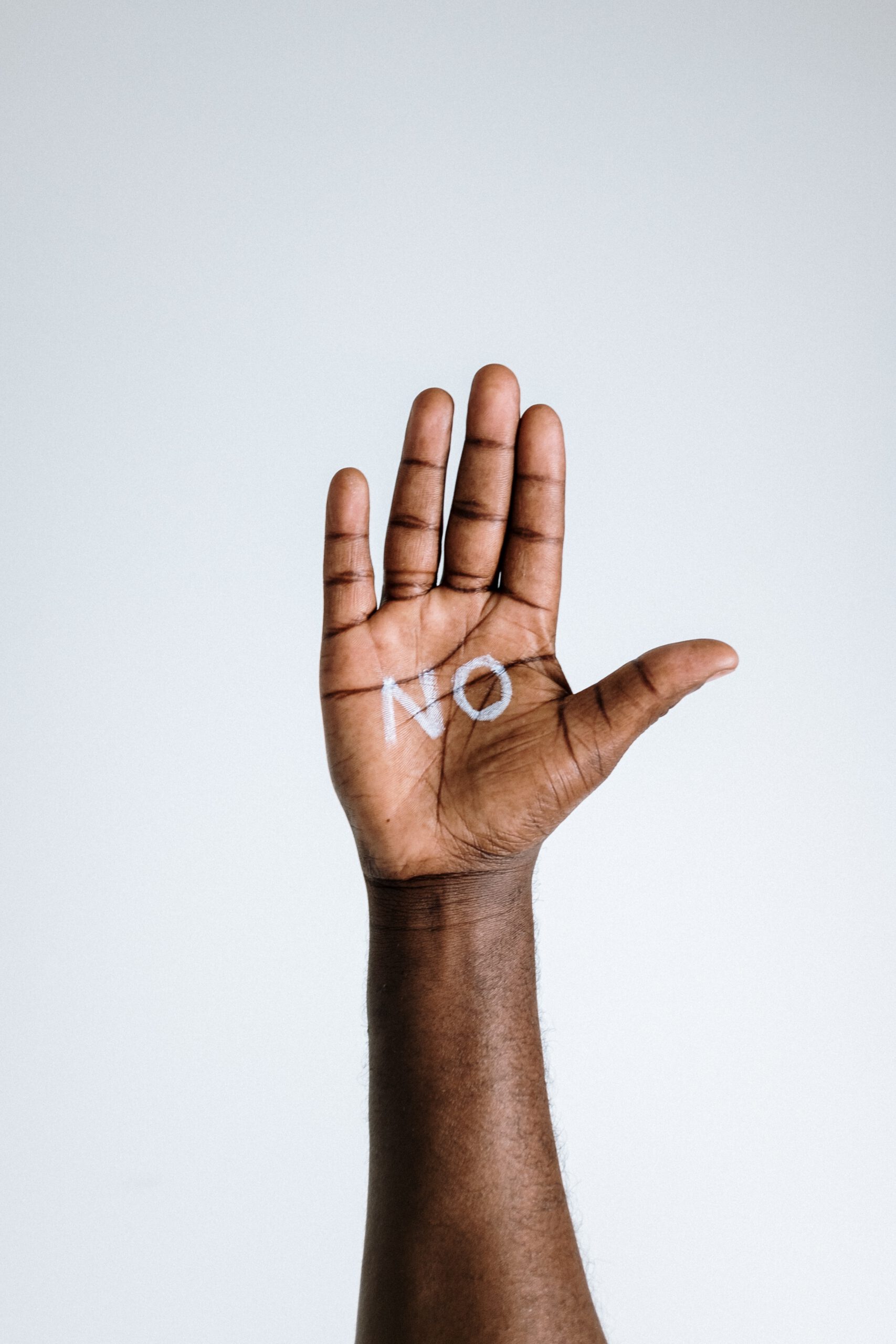 Donkere hand waar 'No' met krijt op is geschreven